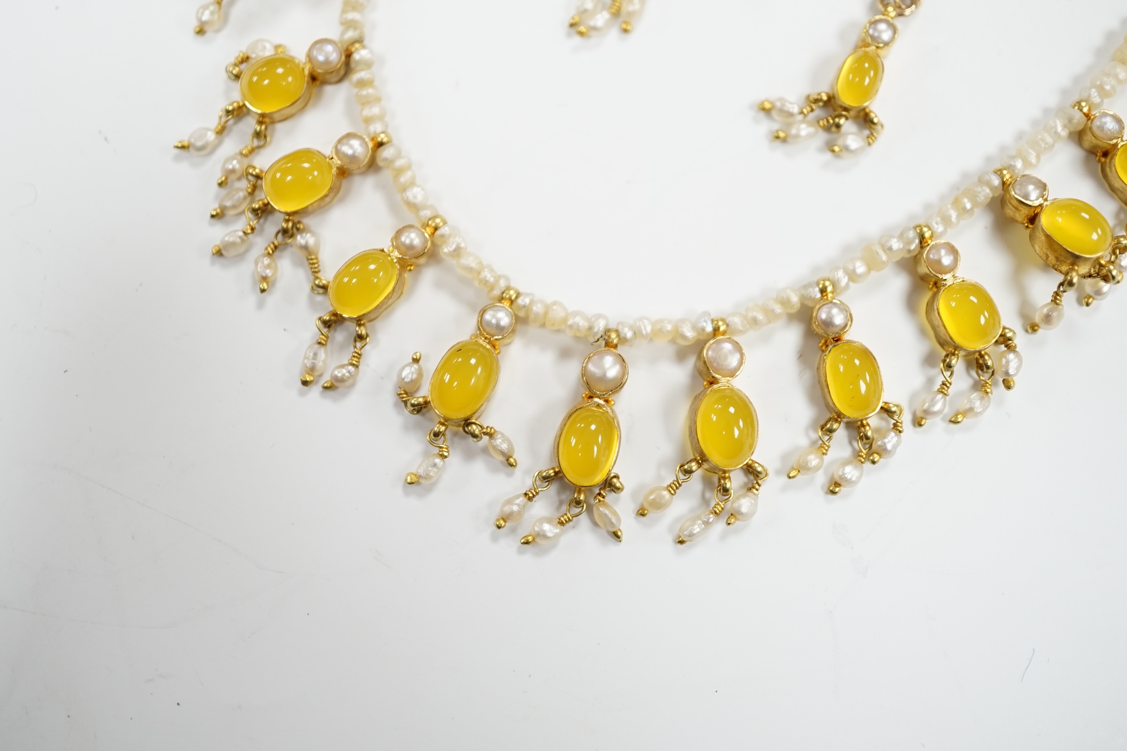 An early 20th century seed pearl and yellow chalcedony set drop necklace with yellow metal clasp, 38cm. and a pair of matching drop ear clips, stamped 375.
